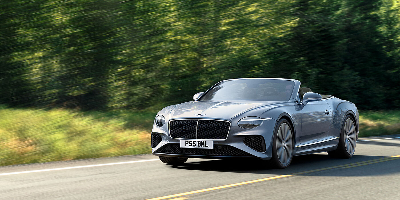 Bentley Belfast New Bentley Continental GTC convertible front view in Silverlake paint with 22 inch ten spoke wheels, driving dynamically on a country road